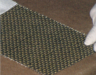 Carbon fiber mesh sheet held by a gloved hand
